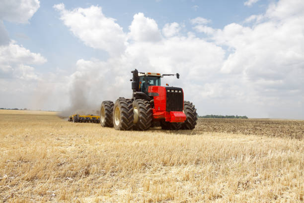 istock Tractor plowing field at summer 954424538