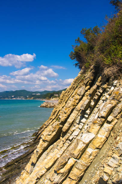 istock rocky sea shore with pebble beach, waves with foam 954427864