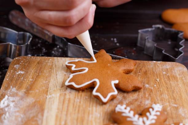 istock Confectioner decorating gingerbread cookies with confectionery i 954427922