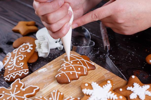 istock Christmas bakery. Decorating homemade gingerbread cookies with i 954428262