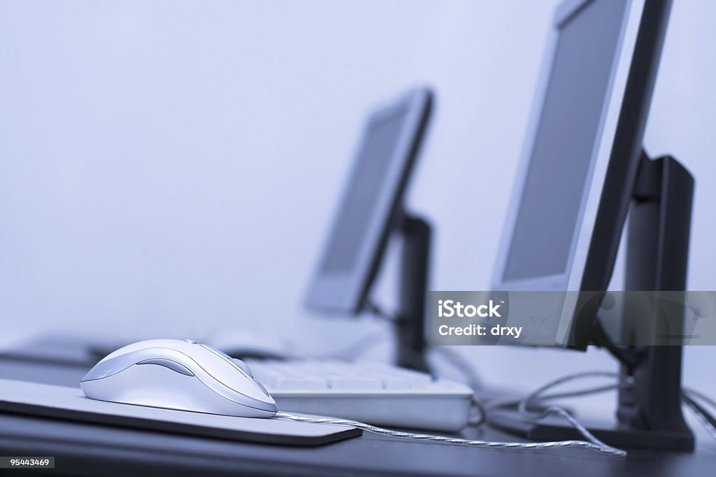 Close up of mouse sitting on desk in computer room Computer classroom. Two computers in line in school classroom Arranging Stock Photo