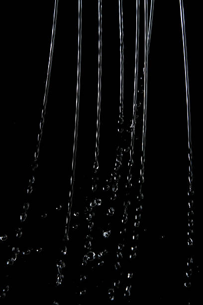 gouttelettes d'eau sur fond noir - gicler photos et images de collection