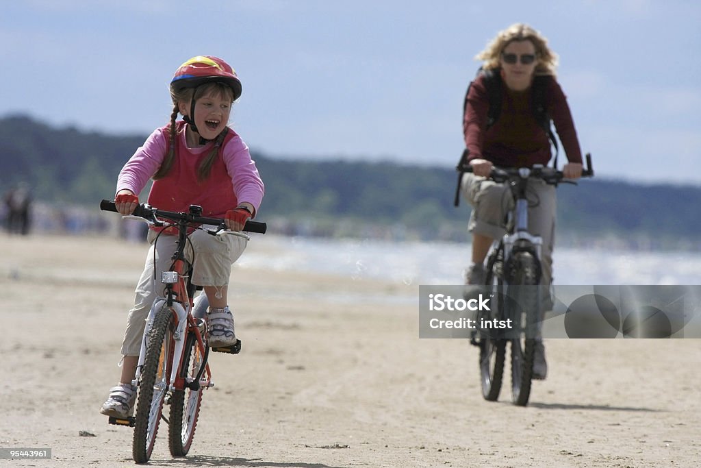 Mãe e filha dirigindo ao longo da praia - Royalty-free Bicicleta Foto de stock