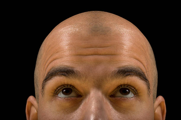 A bald man looking like he is thinking Bald man head looking up thinking, with focus on eyes completely bald stock pictures, royalty-free photos & images
