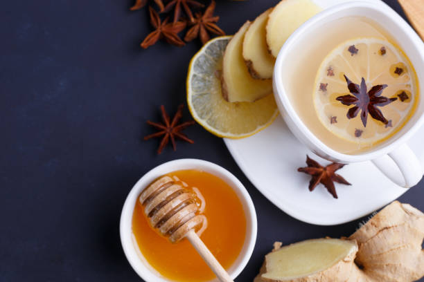 istock Hot spicy ginger tea in white cup with lemon, honey and spices o 954441912