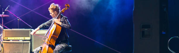 istock Young woman playing cello on the stage 954444592