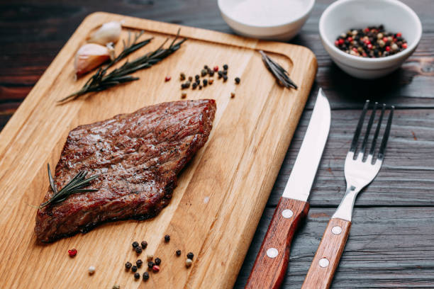 istock Appetizing grilled beef steak on wooden cutting board with rosem 954465670