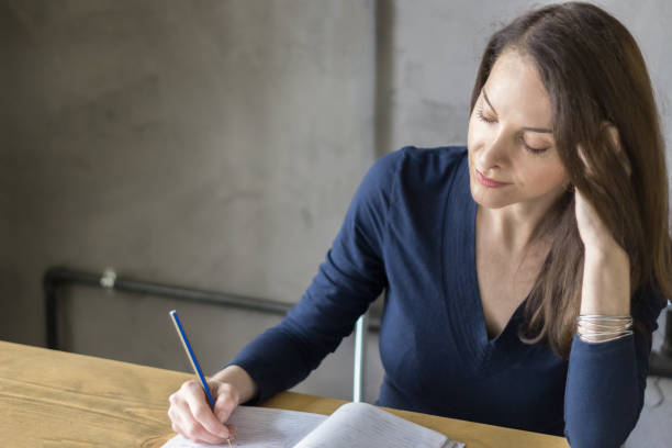 istock Adult woman studying writing on a notebook concentrated. 954470758
