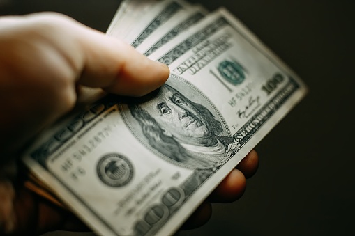 Hombre de la mano con una pila de billetes de cien dólares de los Estados Unidos, cerca photo