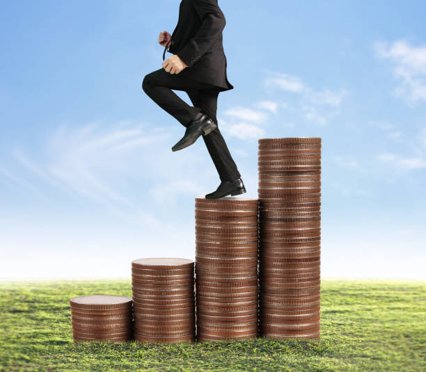istock Businessman walk on stack of coins which grows success 954478428