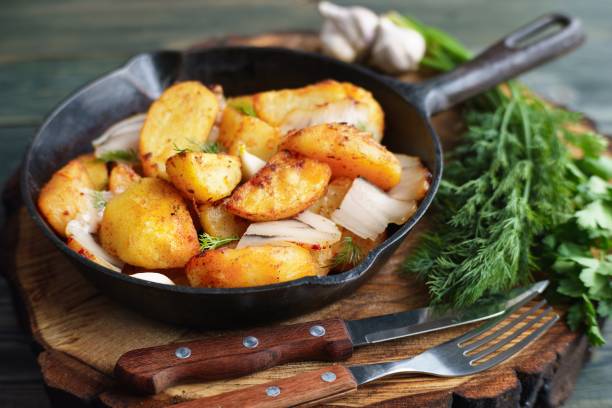 istock Appetizing hot roasted potatoes with bacon  served with cutlery 954478978