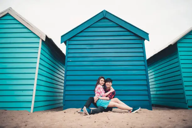 Australia Prewedding Engagement Portrait couple in front of blue bathhouse sitting