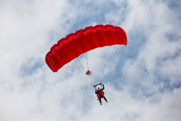 istock Parachuter descending with a red parachute 954490728