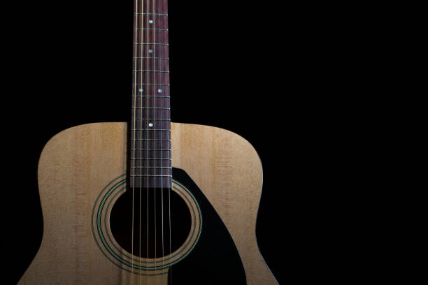 istock New acoustic guitar on black background 954495476