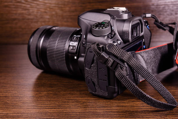 istock Modern dslr camera on the dark wooden table 954495786