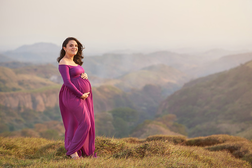 One pregnant woman on sunset landscape with copy space