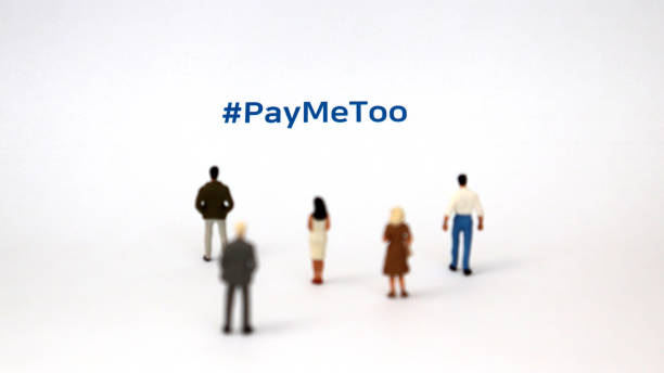 #paymetoo jako nowa kampania mająca na celu wypełnienie różnicy w wynagrodzeniach kobiet i mężczyzn. miniaturowy mężczyzna i miniaturowa kobieta stojąca na kartce papieru z #paymetoo na nim. - gender symbol human gender male sexual issues zdjęcia i obrazy z banku zdjęć