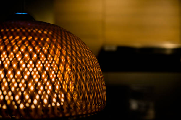 istock Close Up of Luxury Woven Bamboo Lamp with Yellow Light Inside.Openwork wicker lampshade.old fashion lamp. Copy space 954505192