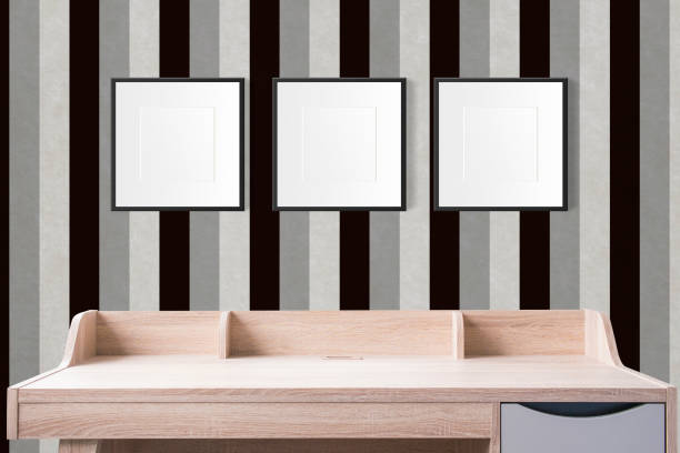istock working table with blank photo frames in the empty studio with vintage black and white wallpaper. 954509178