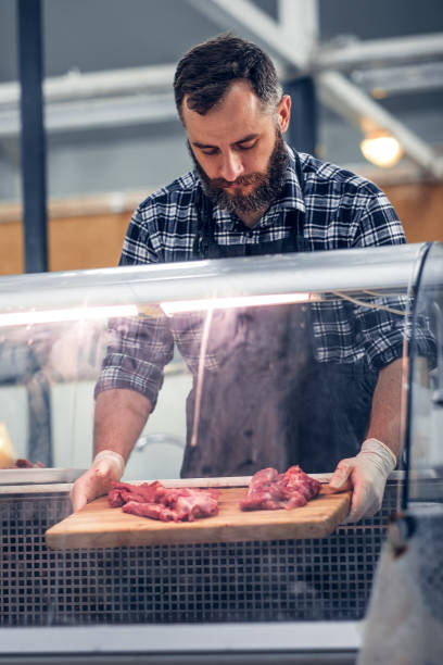 istock Bearded meat seller serving fresh cut meat. 954514680