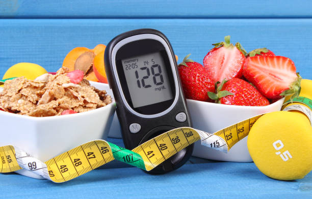 Glucose meter with sugar level, healthy food, dumbbells and centimeter, diabetes, healthy and sporty lifestyle Glucometer with result of measurement sugar level, healthy food, dumbbells for fitness and tape measure, concept of diabetes, slimming, healthy lifestyle blood sugar test stock pictures, royalty-free photos & images