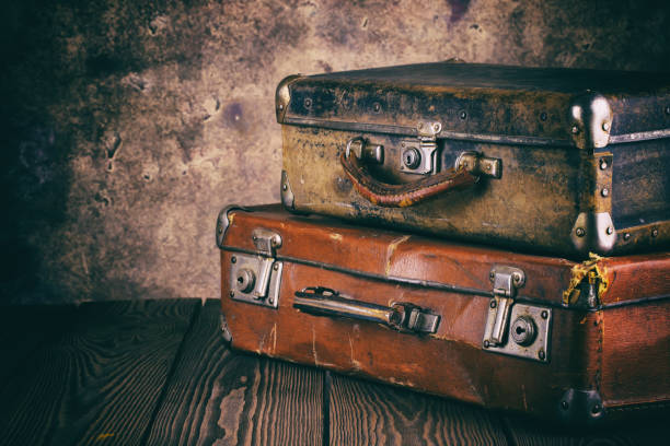 istock Fragment of old leather suitcases on wooden table 954518080