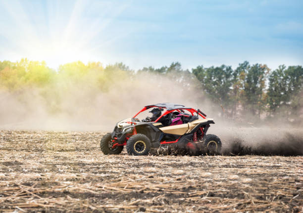 quad bike sur un champ labouré au soleil - off road vehicle quadbike quad racing motocross photos et images de collection