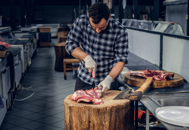Portrait of a butcher holds an axe and fresh cut meat.
