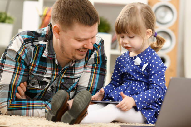 istock Cute little girl on floor carpet with dad 954518510
