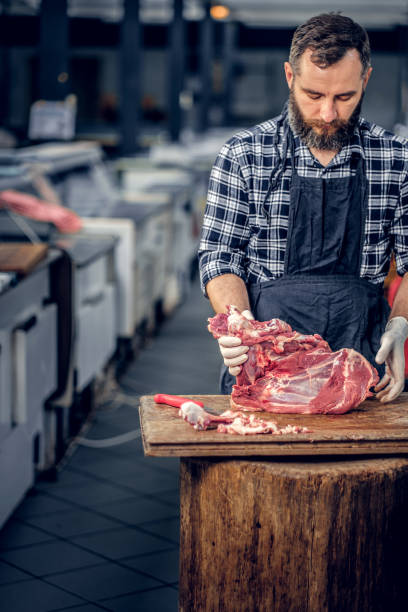 istock Bearded butcher cut fresh bacon meat. 954518736