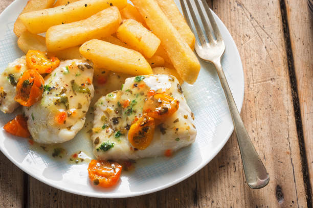 cod fillets with cherry tomato, white wine & basil dressing served with chips - pollock trawler imagens e fotografias de stock