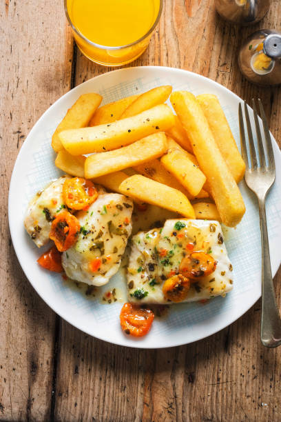 cod fillets with cherry tomato, white wine & basil dressing served with chips - pollock trawler imagens e fotografias de stock