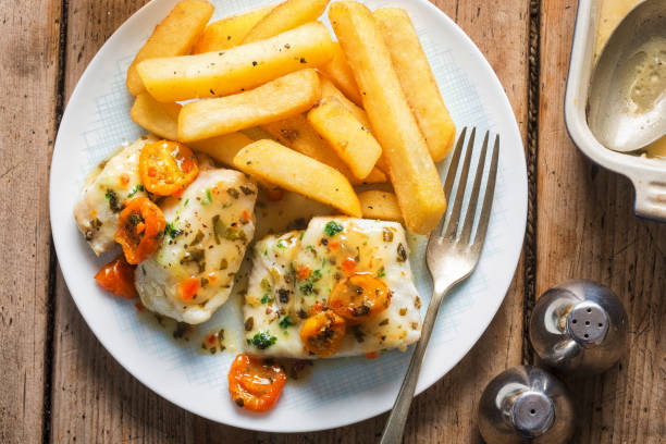 cod fillets with cherry tomato, white wine & basil dressing served with chips - pollock trawler imagens e fotografias de stock