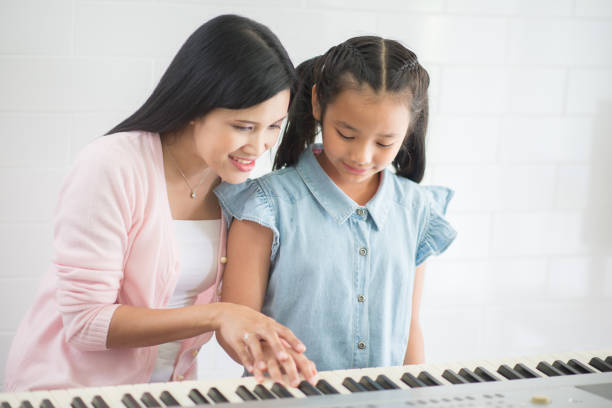frau lehrer unterrichten klavier zu einem gril - music learning child pianist stock-fotos und bilder