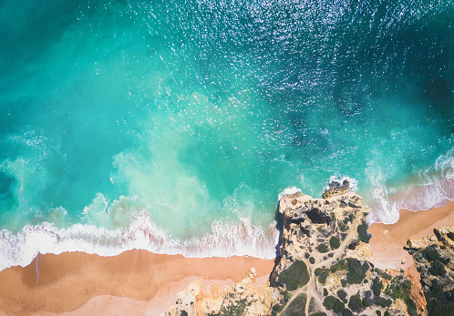 Aerial view of sandy beach and ocean with beautiful clear turquoise water.