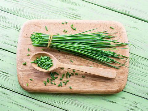 Green onion on the wooden table.