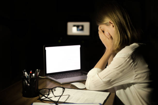 mujer deprimida, trabajando con la computadora en la noche - red hair fotografías e imágenes de stock