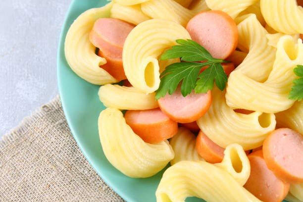 istock Pasta Cavatappi or Cellentani with sausages on a gray table. 954538936