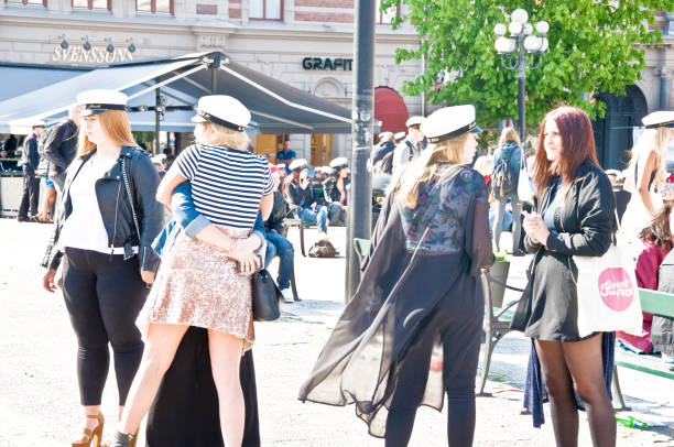 A group of female gymnasium students celebrating at the city square after graduation ceremony and road procession (Studentmössa: Swedish Rites of Passage From Gymnasium). North of Stockholm (Sundsvall, Sweden)