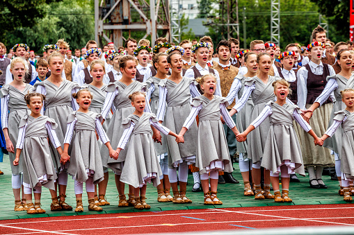 RIGA, LATVIA - JULY 11, 2015: Dancers perform at the Grand Folk dance concert of Latvian Youth Song and Dance Festival in the Daugava Stadium.