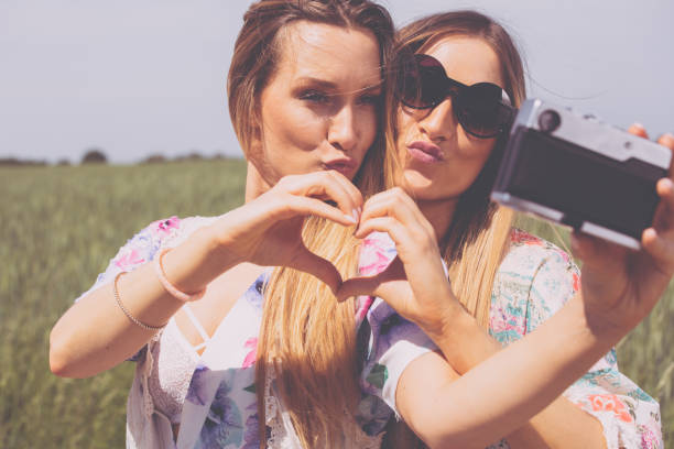 istock twin sisters making a selfie with retro camera 954545618