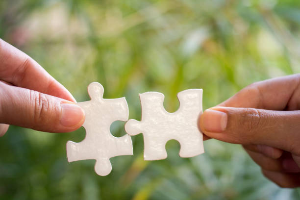 istock Businessman hands connecting jigsaw puzzle. Business solutions, success and strategy, learning concept. 954548732
