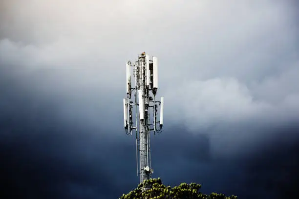 Photo of Cellphone base station mast against stormy sky