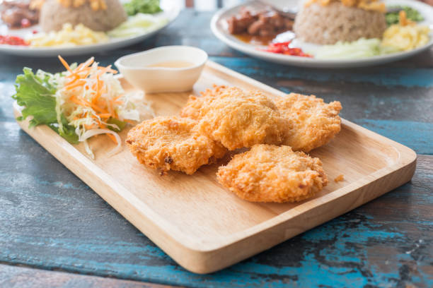 Fried shrimp pancake served with vegetable and sweet dipping sauce on wooden dish