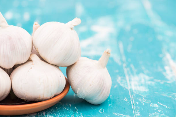 istock Garlic on green wood background 954554386