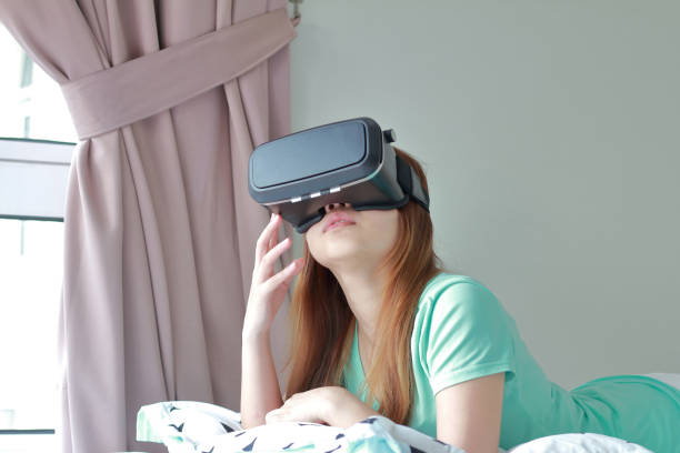 istock Young woman wearing virtual reality glasses at home. 954559164