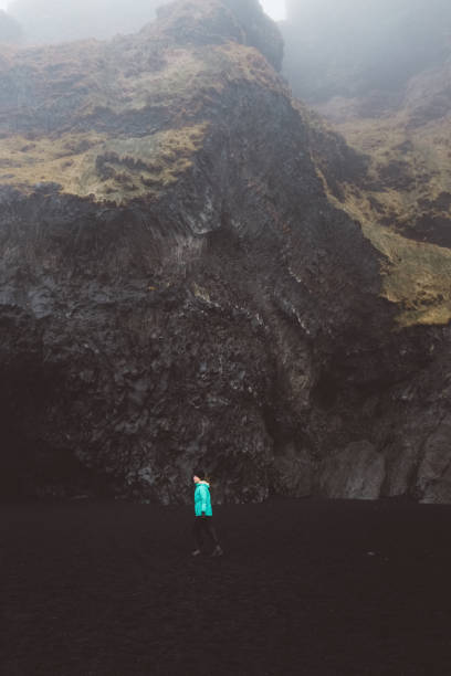 istock Woman walking on black sand beach in Iceland 954559960