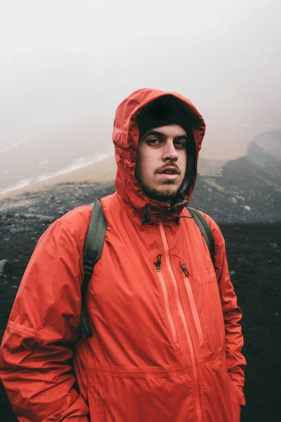 istock Man in red on black sand beach in Iceland 954560308