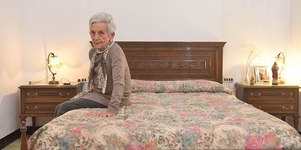 portrait of an elderly woman in a bedroom