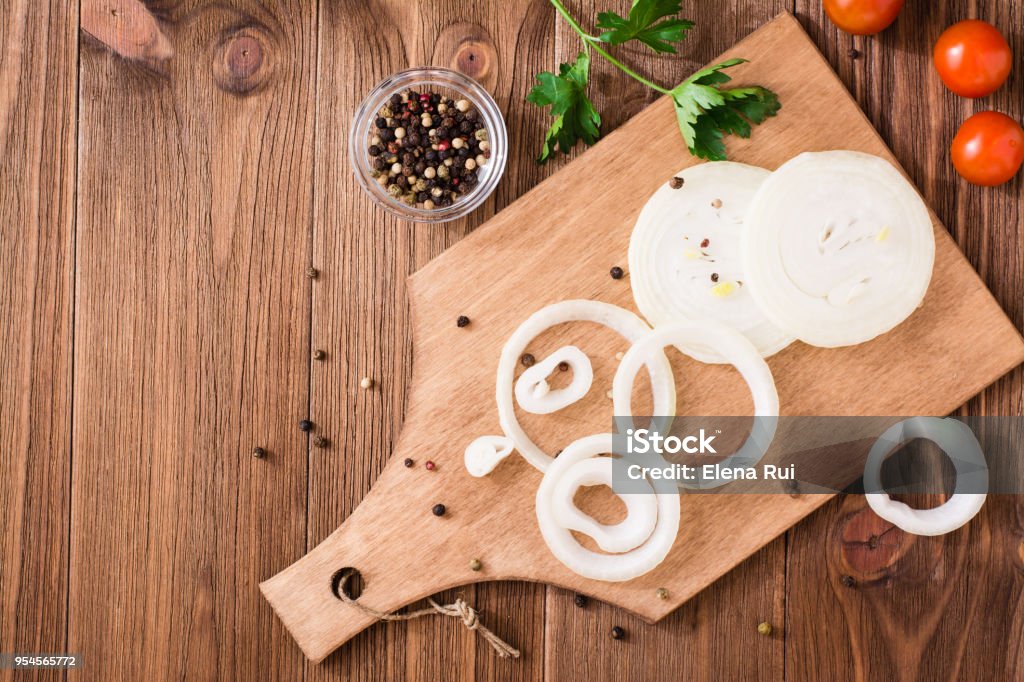Onion rings on a cutting board on a wooden table Onion rings on a cutting board on a wooden table. Top view Onion Stock Photo